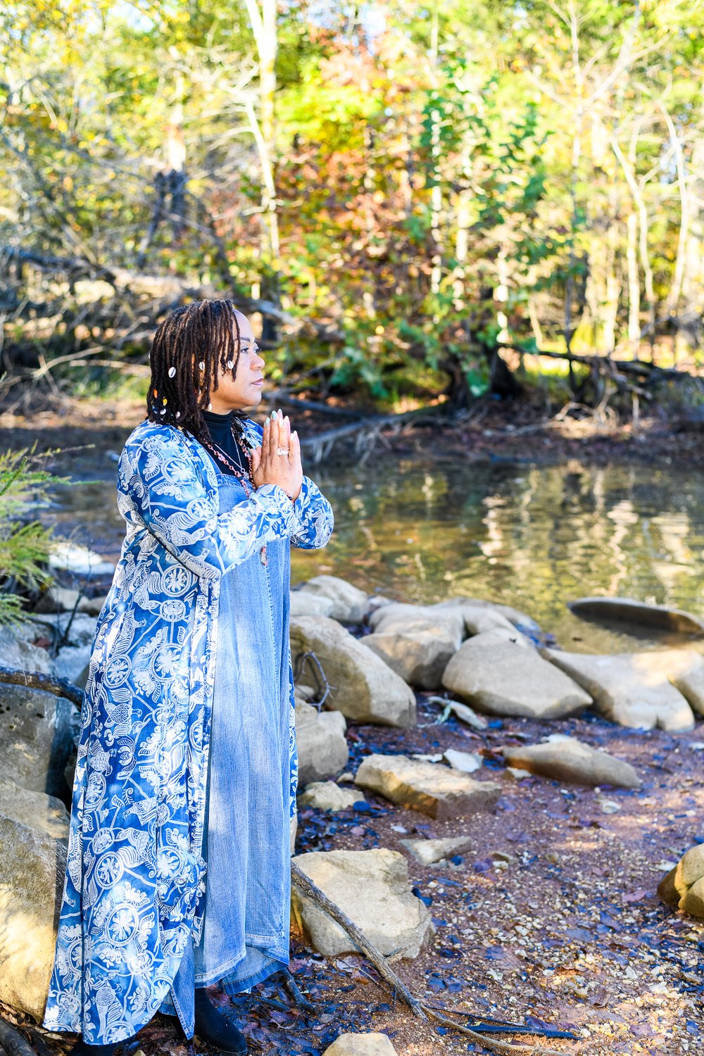 Rosilyn Hart in prayer pose by the creek